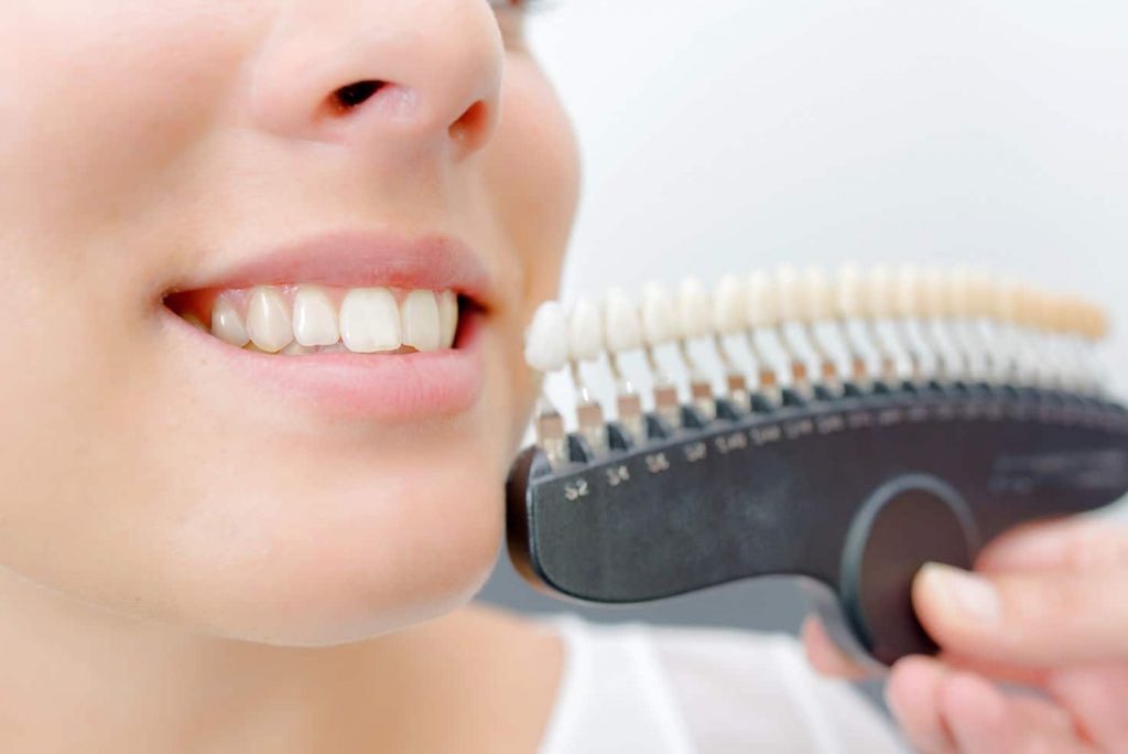 Woman smiling next to fake teeth